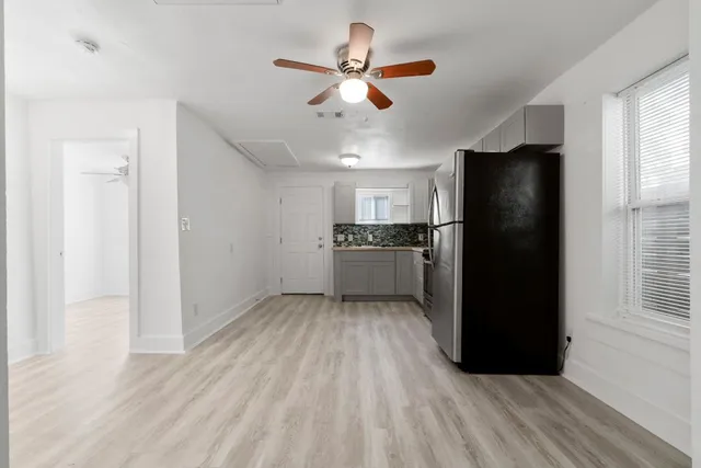 a kitchen with stainless steel appliances granite countertop a refrigerator a oven a sink with wooden floors and cabinets