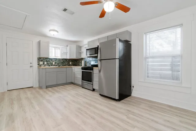 a kitchen with a stove and white cabinets