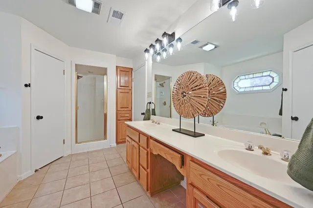 a spacious bathroom with a double vanity sink and a mirror