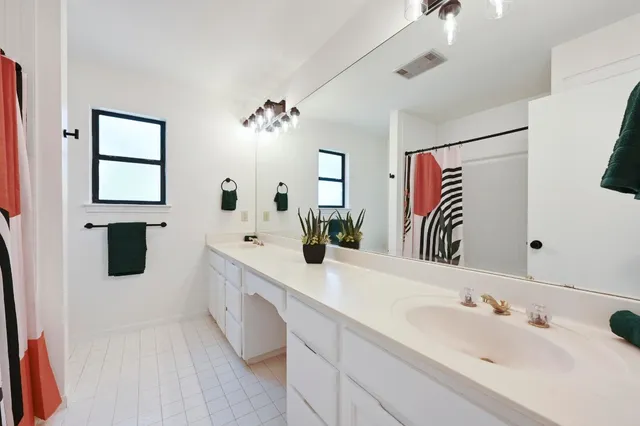 a spacious bathroom with a sinks a vanity and a mirror