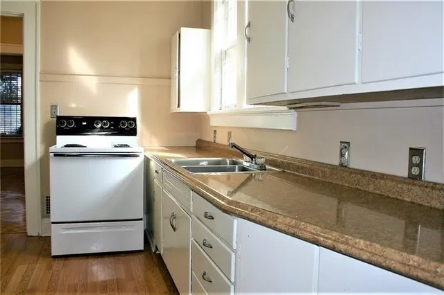 a kitchen with granite countertop a sink and a stove top oven