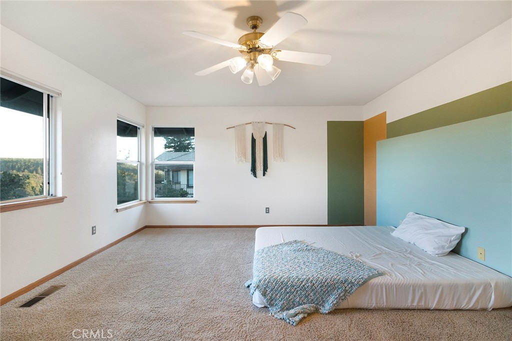 14856 Eagle Ridge Drive Forest Ranch, CA 95942 - Photo 21 of 27 a bedroom with a large bed and a chandelier
