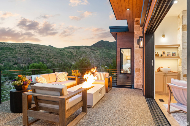 1400 Weber Wild Road Oakley, UT 84055 - Photo 23 of 55 Outdoor living space featuring a concrete fire pit, stone accent wall, and a wood-paneled ceiling with recessed lighting