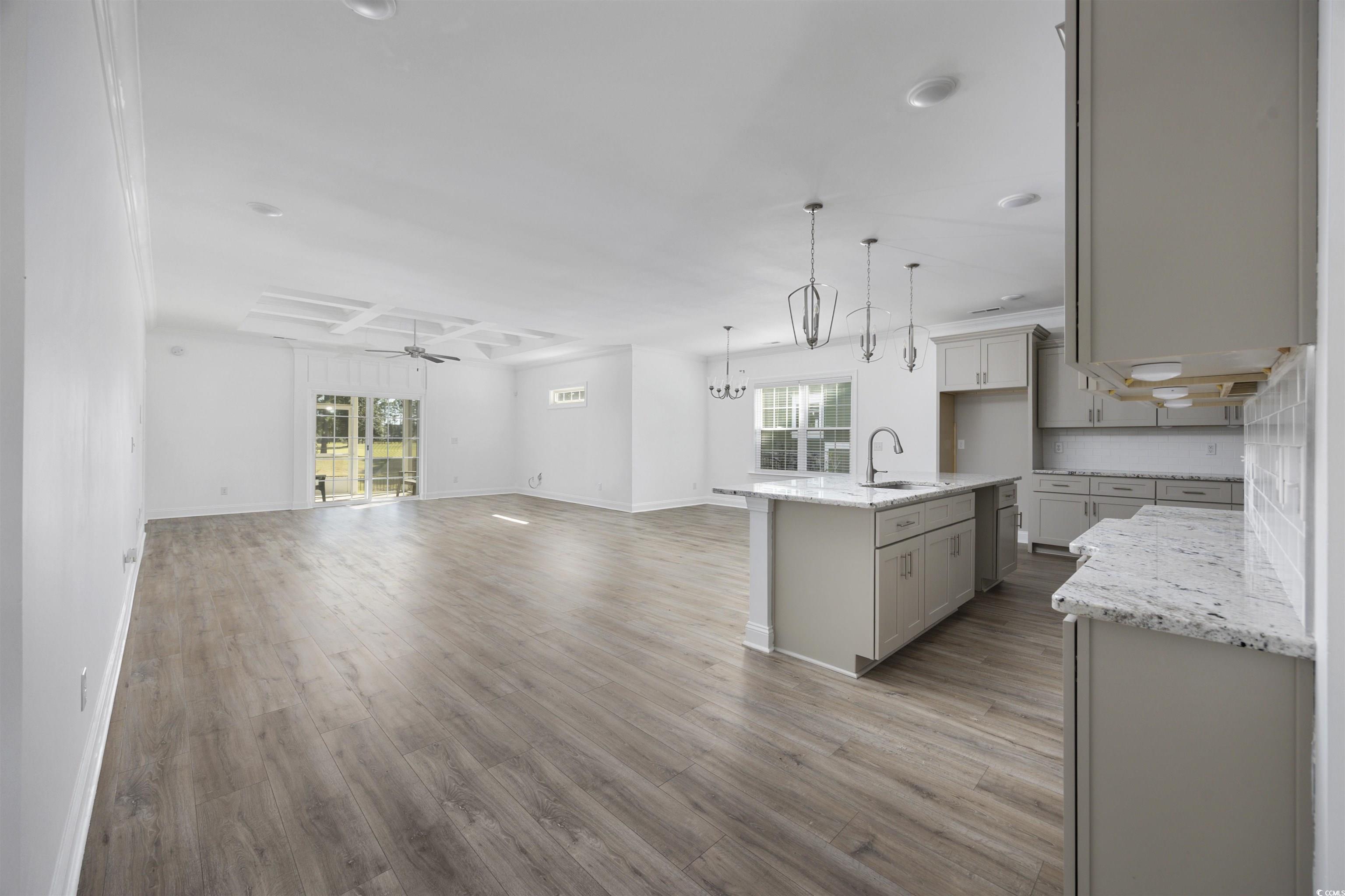 1108 Pochard Drive Conway, SC 29526 - Photo 5 of 37 Kitchen featuring light stone counters, a ceiling fan, an island with sink, light wood-type flooring, and hanging light fixtures