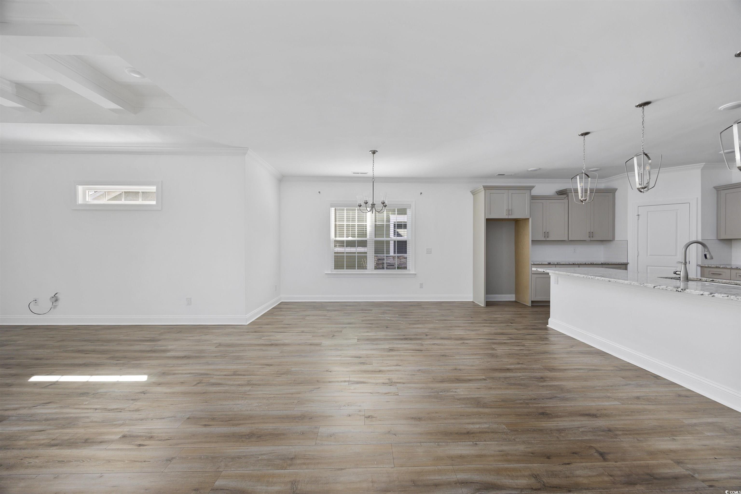 1108 Pochard Drive Conway, SC 29526 - Photo 6 of 37 Unfurnished living room with a chandelier, dark wood-style flooring, and ornamental molding