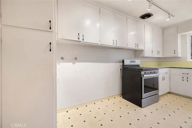 a kitchen with granite countertop white cabinets and white appliances