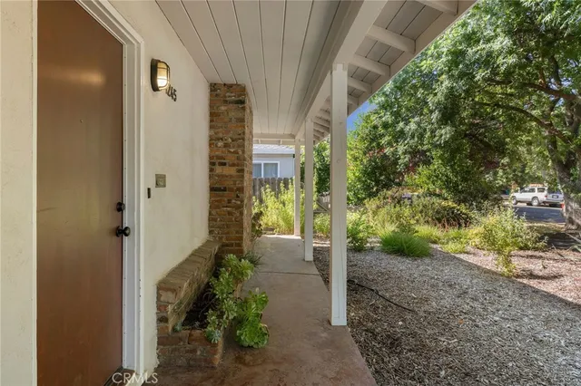 an empty room with wooden floor fireplace and windows