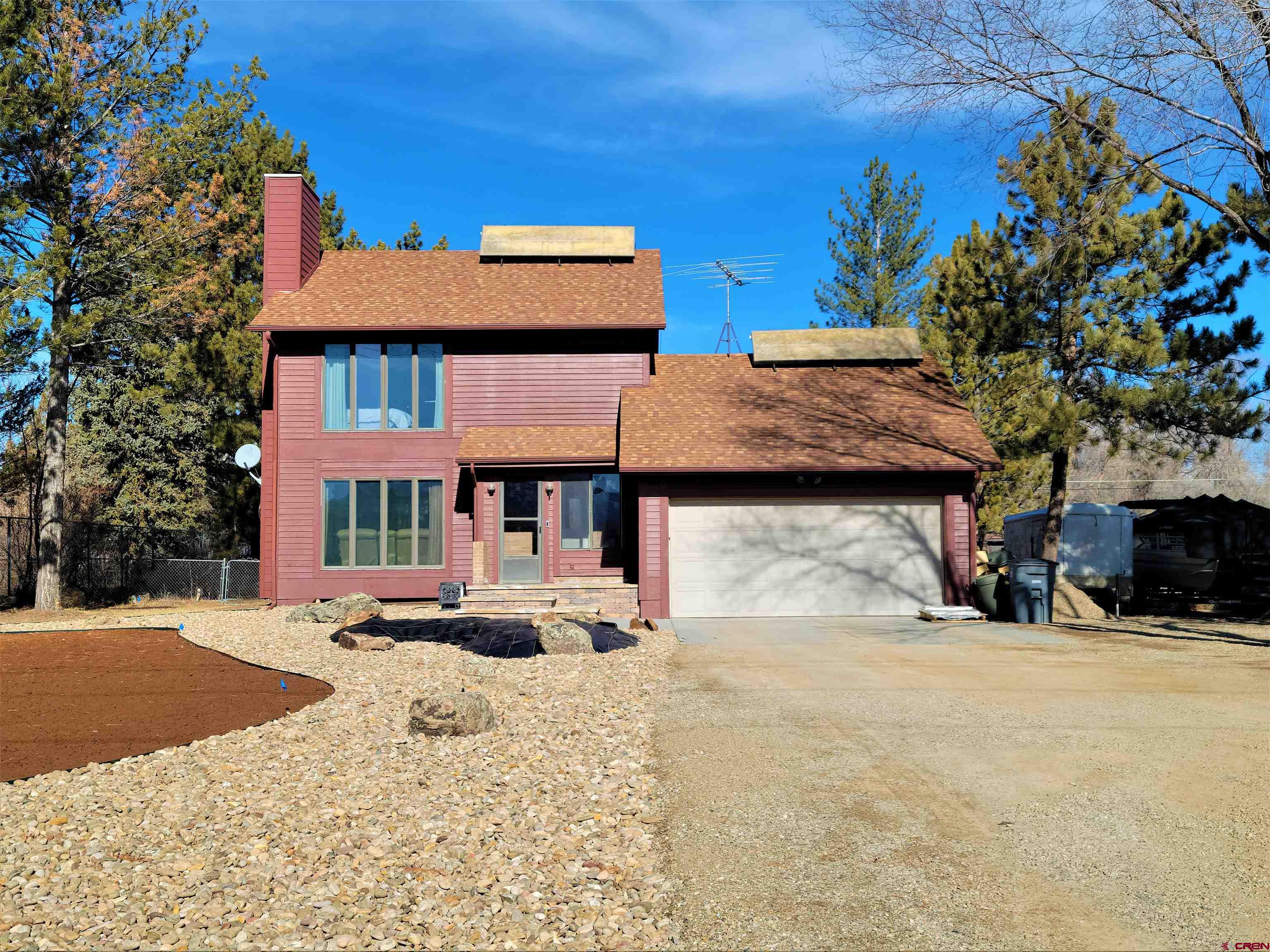 a front view of a house with a yard covered with snow and trees