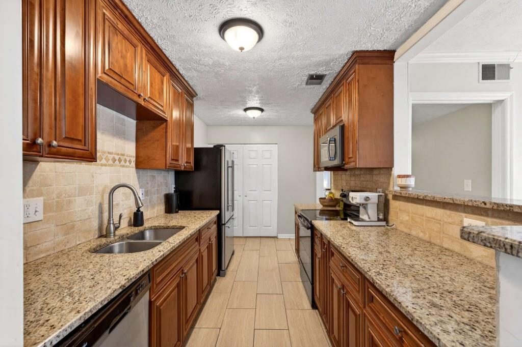 725 Dalrymple Road, Unit 5F Sandy Springs, GA 30328 - Photo 12 of 33 a kitchen with stainless steel appliances granite countertop a sink a stove and a refrigerator
