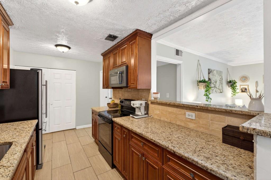 725 Dalrymple Road, Unit 5F Sandy Springs, GA 30328 - Photo 15 of 33 a large kitchen with granite countertop a sink and a refrigerator