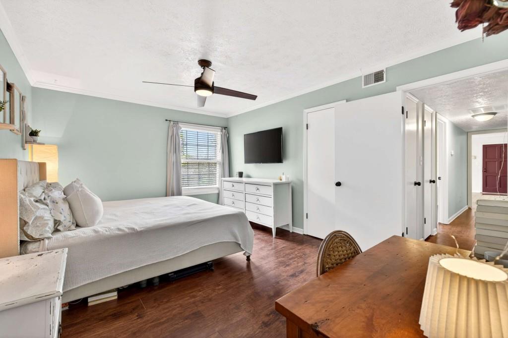 725 Dalrymple Road, Unit 5F Sandy Springs, GA 30328 - Photo 21 of 33 a bedroom with a bed a flat tv screen and a dresser