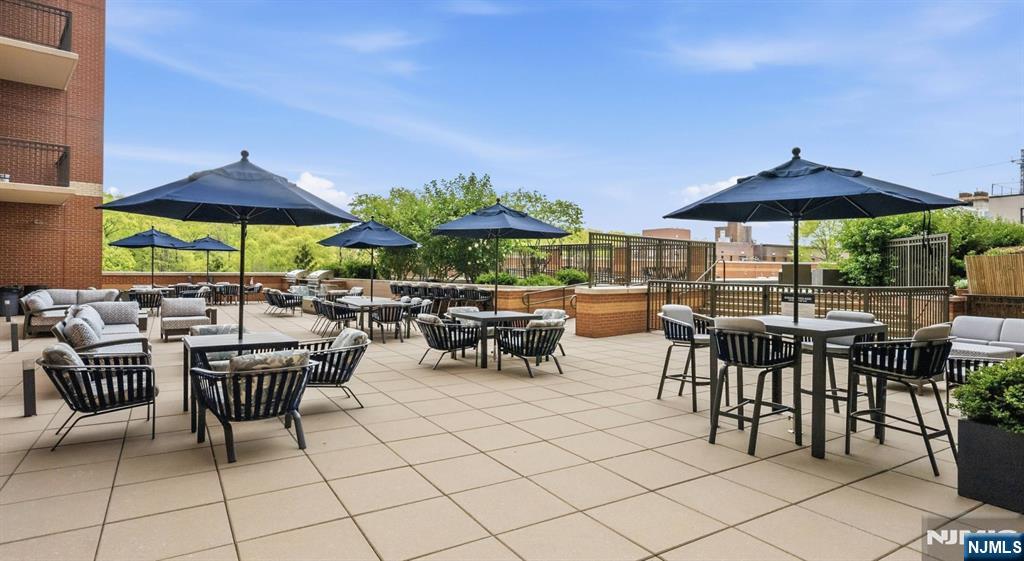 2050 North Central Road, Unit 710 Fort Lee, NJ 07024 - Photo 16 of 21 a view of a patio with chairs and table under an umbrella