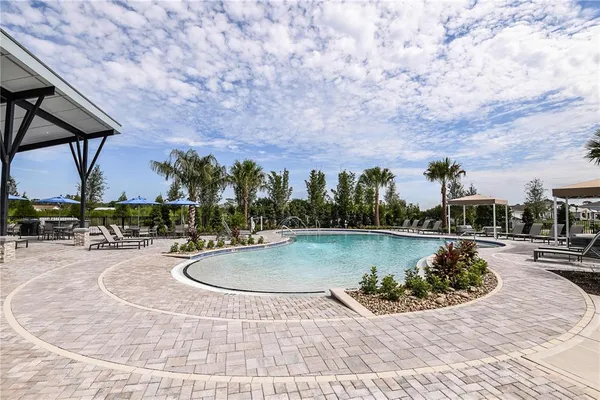 a view of a swimming pool with a patio and a yard