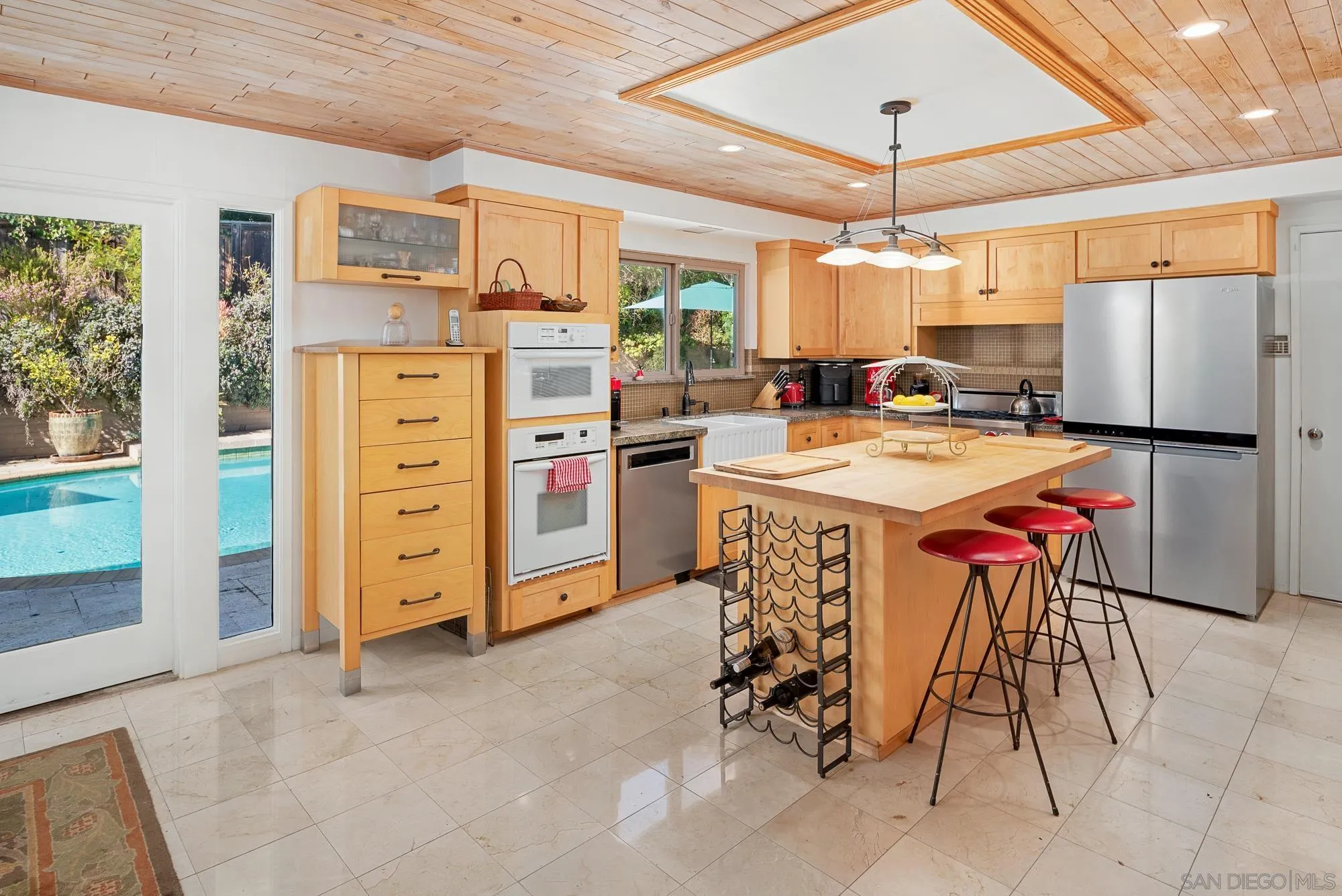 1669 Los Altos Road San Diego, CA 92109 - Photo 11 of 62 a kitchen with stainless steel appliances kitchen island granite countertop a table chairs and a refrigerator