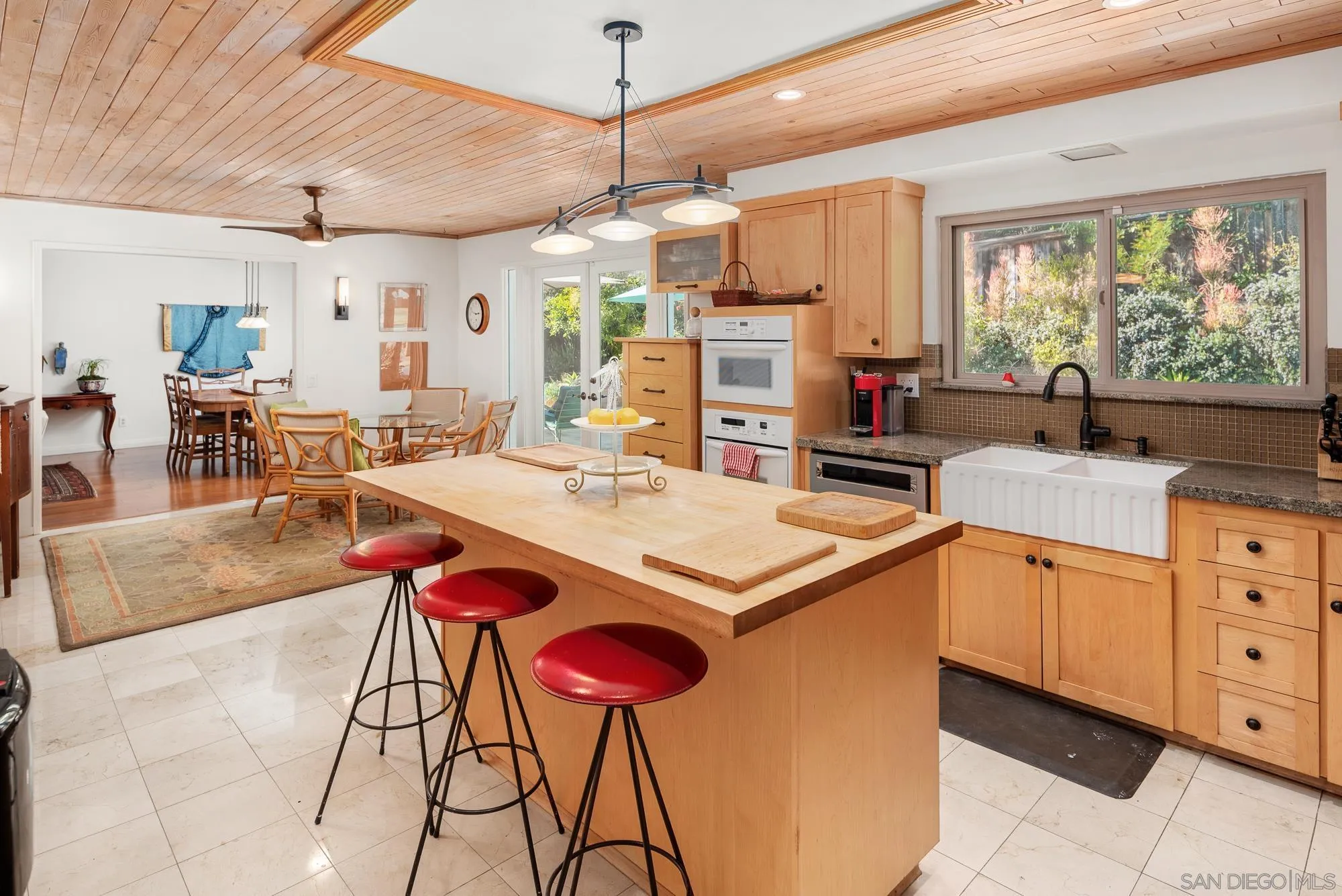 1669 Los Altos Road San Diego, CA 92109 - Photo 15 of 62 a kitchen with stainless steel appliances kitchen island granite countertop a table chairs sink and cabinets