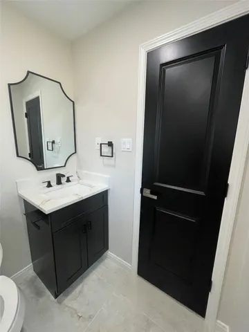 a bathroom with a sink vanity and mirror