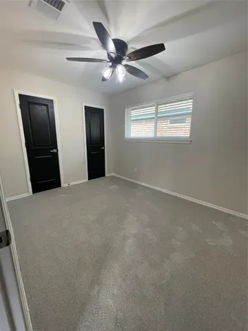 an empty room with closet and windows