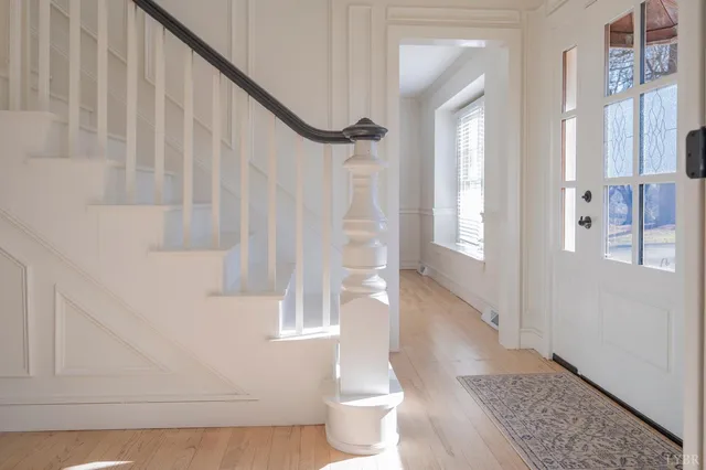 a view of a hallway with wooden floor and stairs