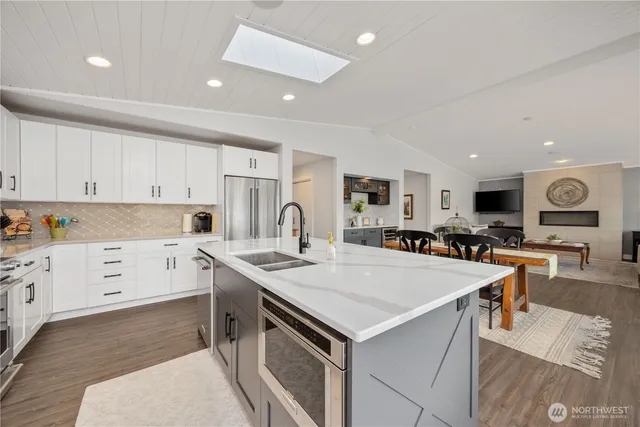 a kitchen with granite countertop white cabinets and appliances