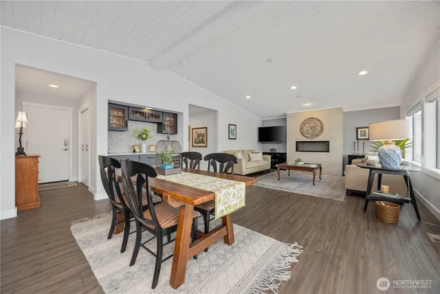 a kitchen with a sink a stove a refrigerator and white cabinets with wooden floor