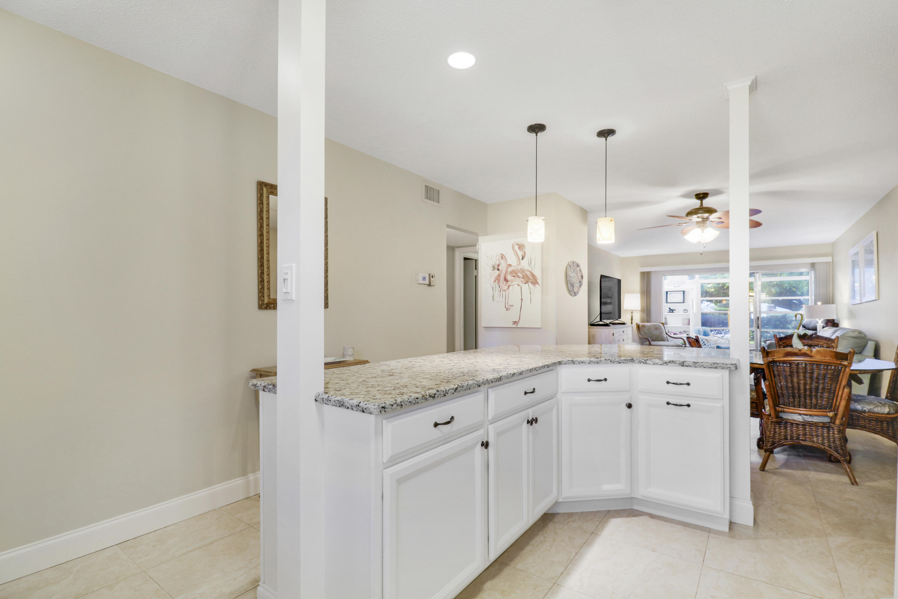 2929 Southeast Ocean Boulevard, Unit 1122 Stuart, FL 34996 - Photo 11 of 37 a large white kitchen with a lot of cabinets and wooden floor