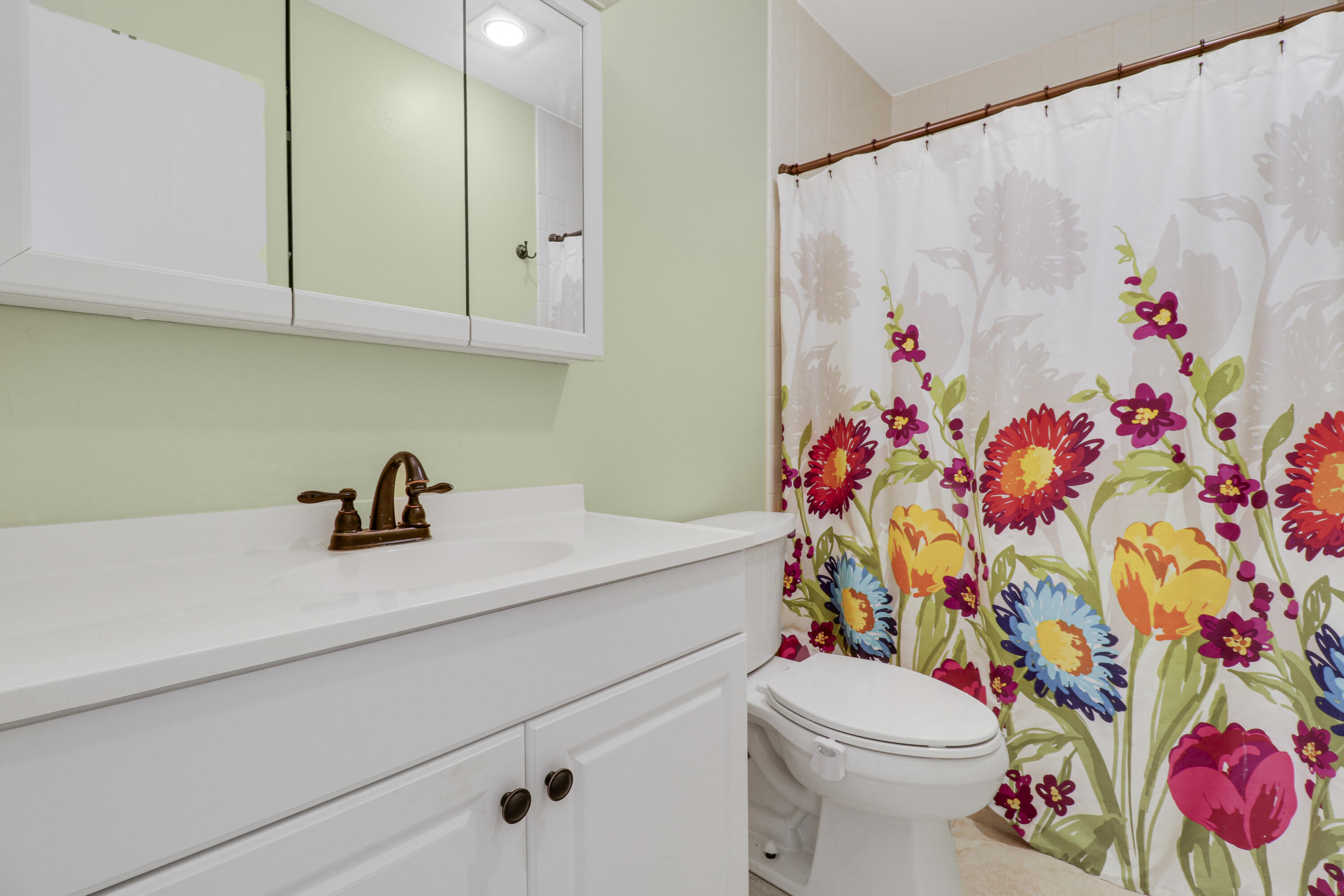2929 Southeast Ocean Boulevard, Unit 1122 Stuart, FL 34996 - Photo 20 of 37 a bathroom with a sink a toilet and shower curtain