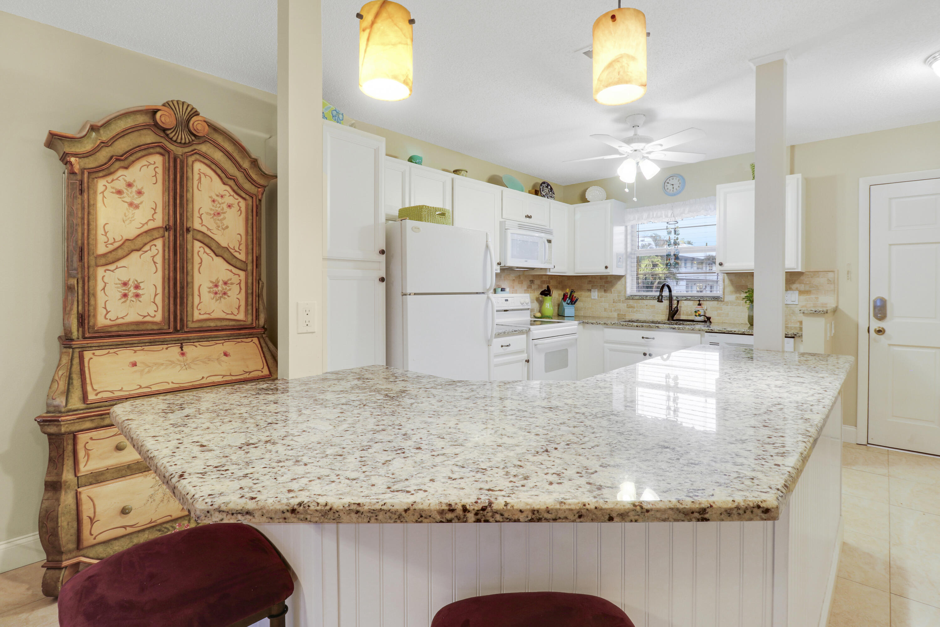 2929 Southeast Ocean Boulevard, Unit 1122 Stuart, FL 34996 - Photo 8 of 37 a kitchen with kitchen island granite countertop a sink a stove and a refrigerator