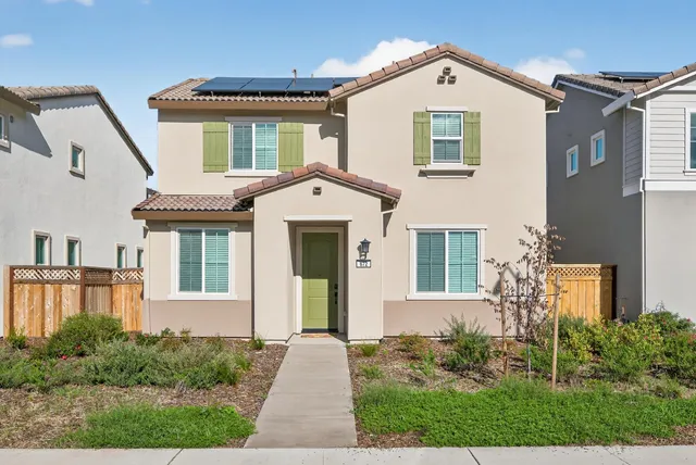 a front view of a house with a yard and trees
