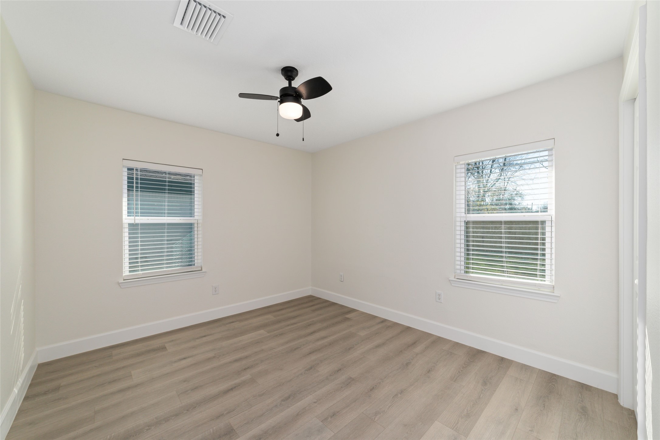 714 East 43rd Street Houston, TX 77022 - Photo 11 of 20 a view of an empty room with a window and wooden floor