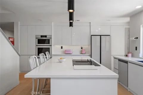 a view of kitchen with refrigerator stove dining table and chairs