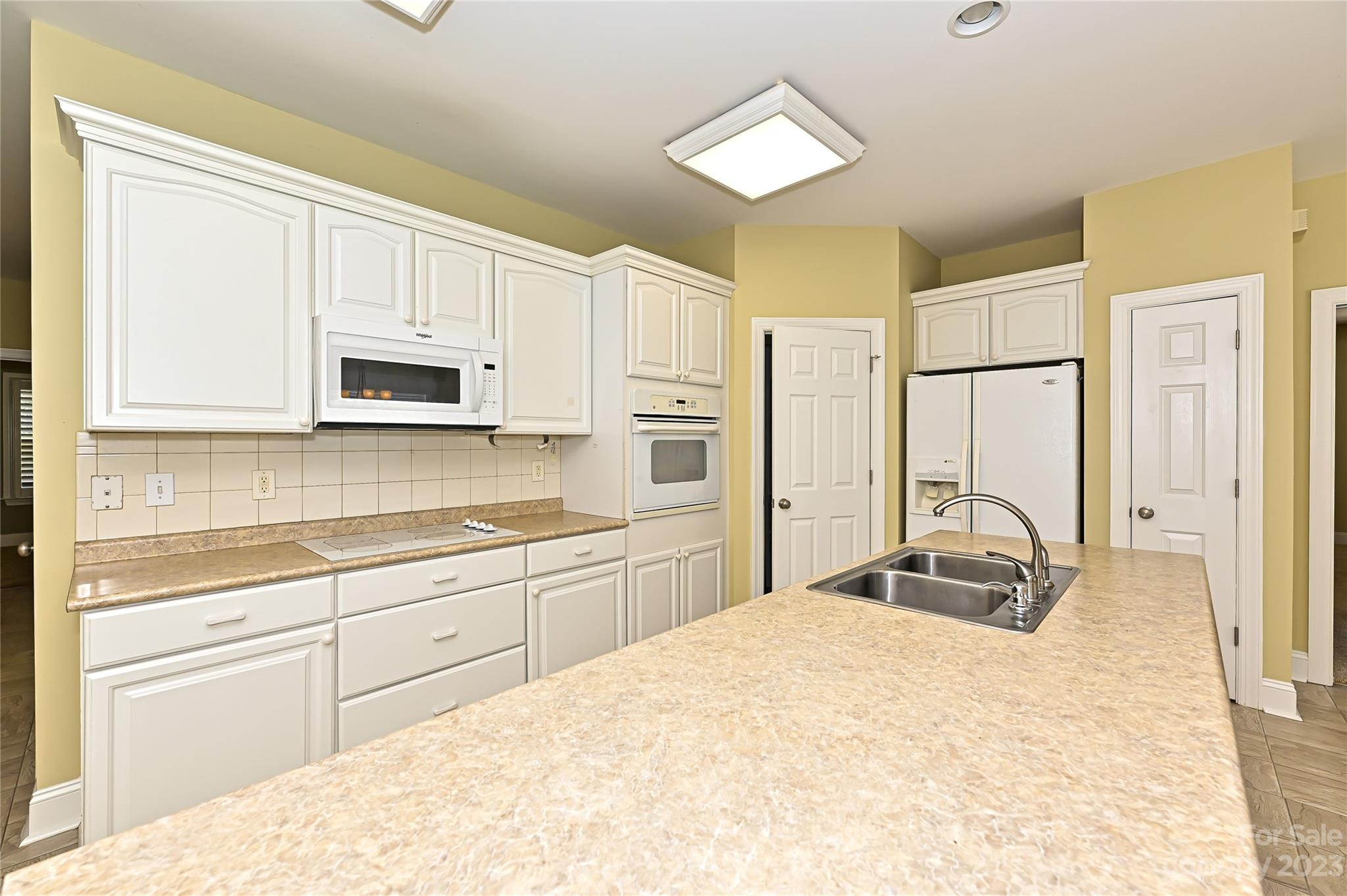 8834 Wingard Road Waxhaw, NC 28173 - Photo 10 of 46 a large white kitchen with stainless steel appliances granite countertop a stove a sink and a refrigerator
