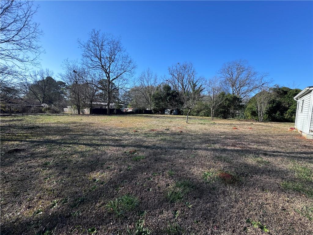 209 Denham Street Thomaston, GA 30286 - Photo 2 of 13 a view of dirt field with trees