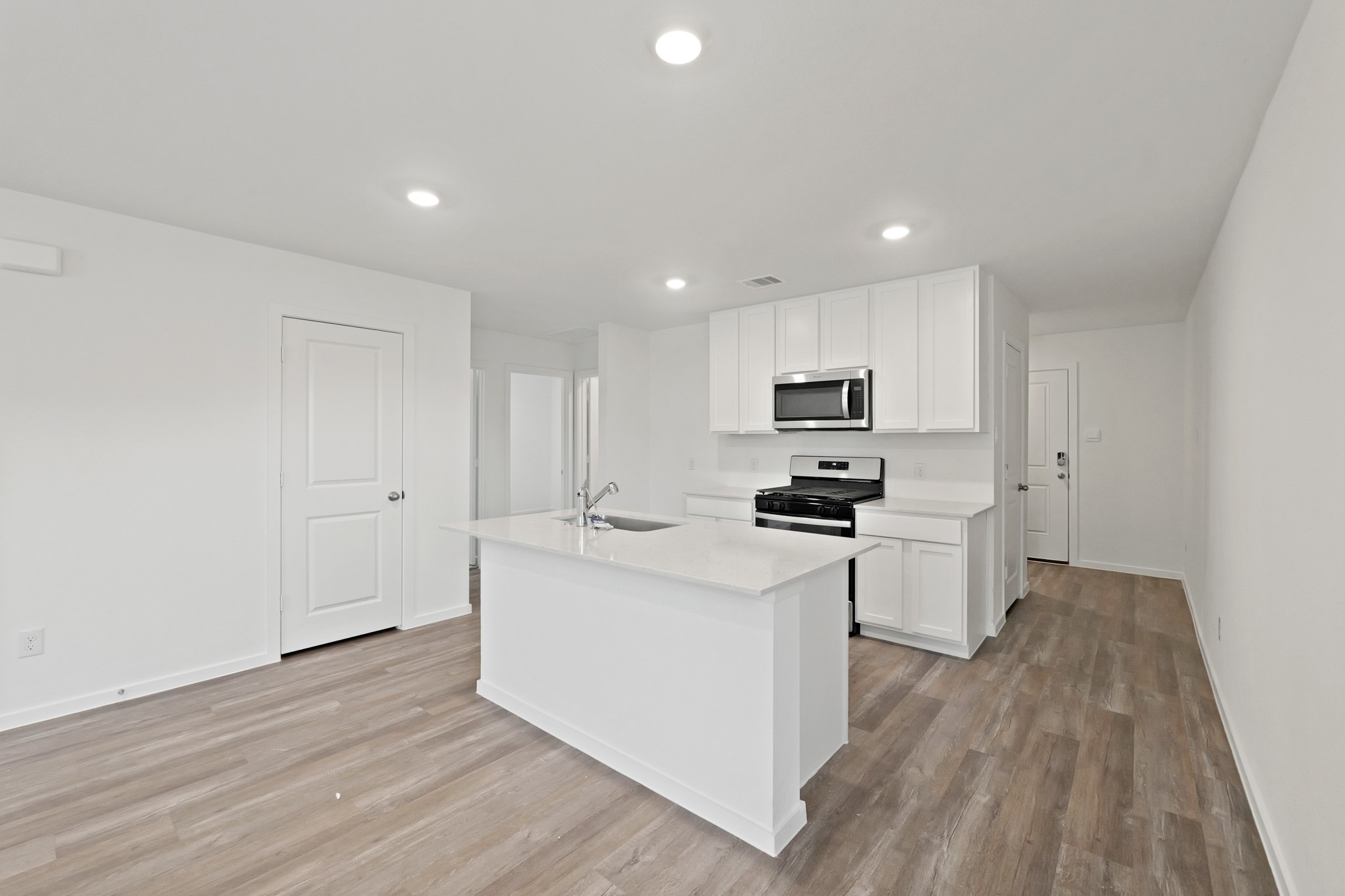 a kitchen with white cabinets stainless steel appliances and sink