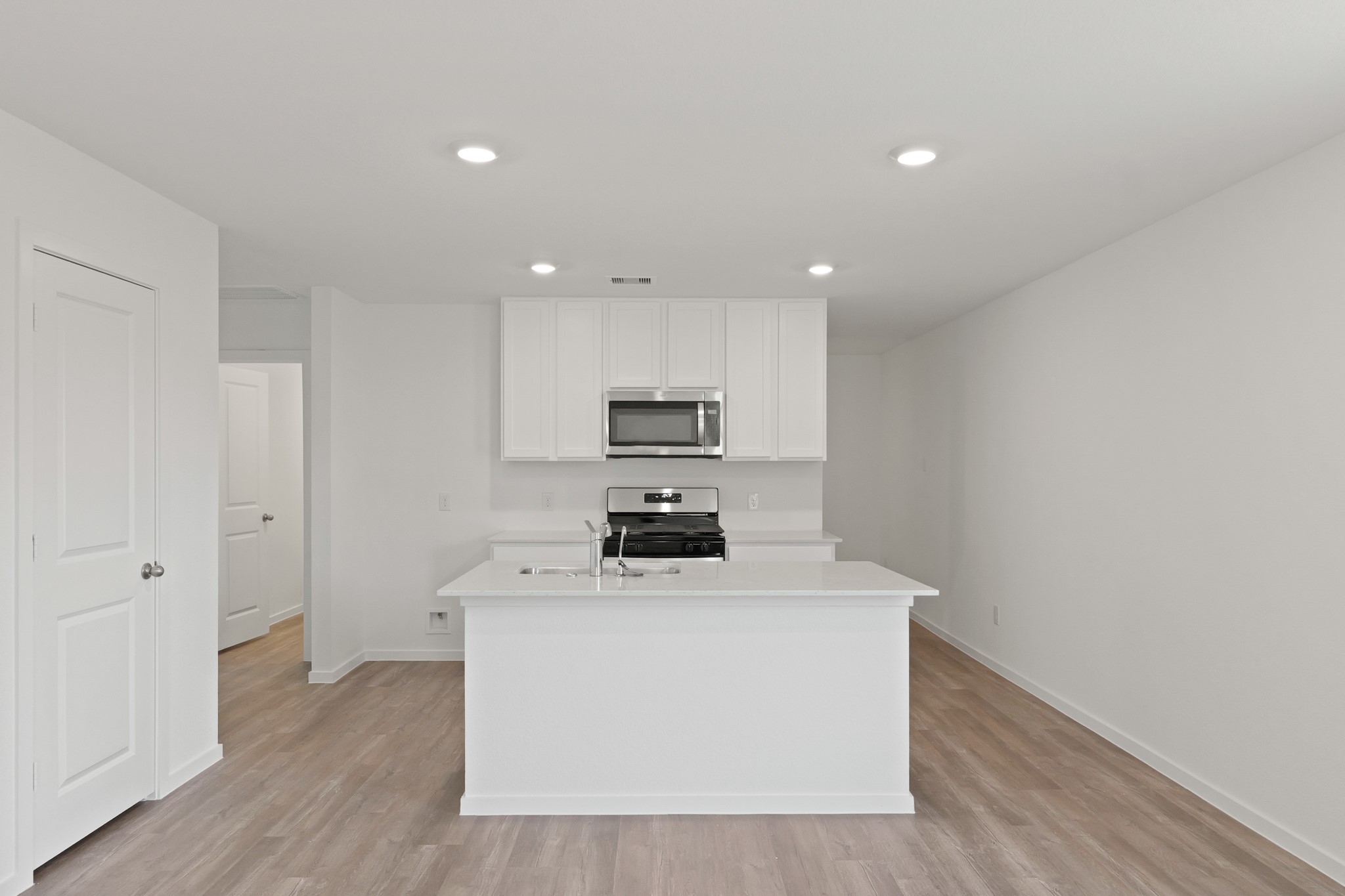 22710 Ravine Edge Court Hockley, TX 77447 - Photo 3 of 23 a kitchen with wooden floor stainless steel appliances and cabinets