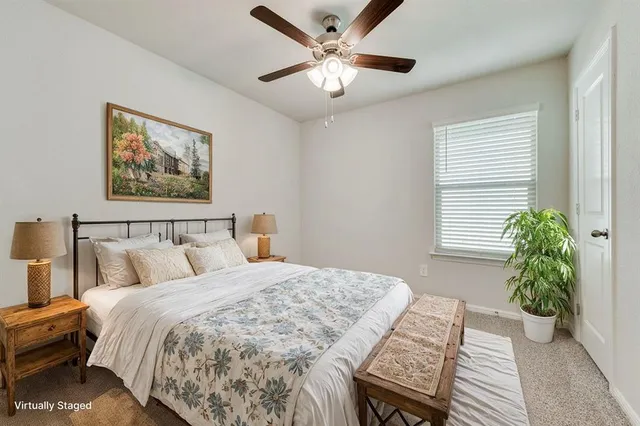 a bed sitting in a bedroom next to a window and a chandelier