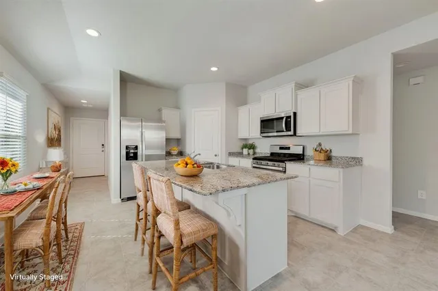 a kitchen with a sink a counter top space stainless steel appliances and cabinets