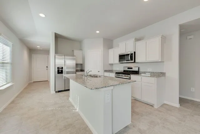 a kitchen with stainless steel appliances granite countertop a refrigerator sink and cabinets