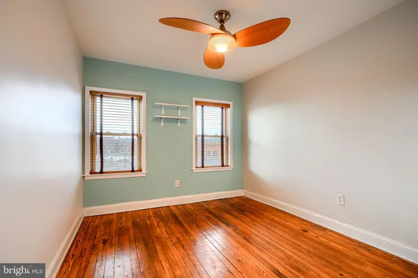 an empty room with window and wooden floor