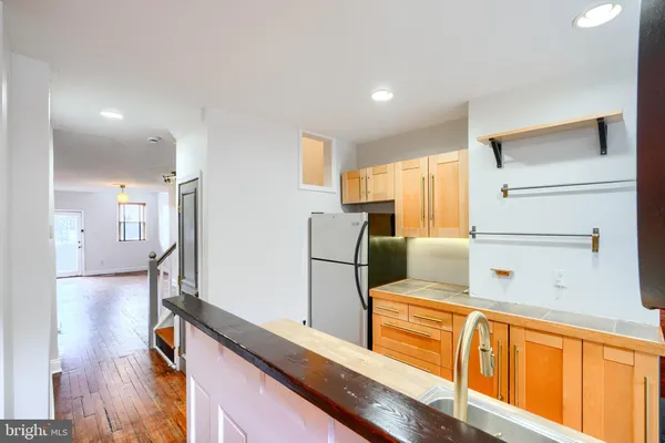 a kitchen with stainless steel appliances granite countertop a sink and a refrigerator