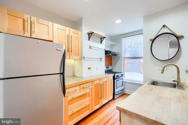 a kitchen with stainless steel appliances granite countertop a refrigerator sink stove and a refrigerator