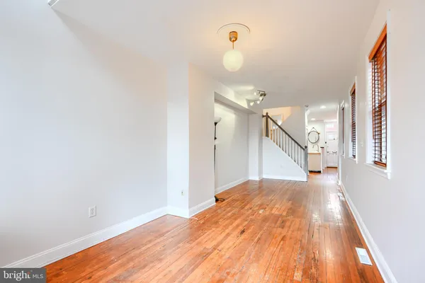 a view of a big room with wooden floor and windows