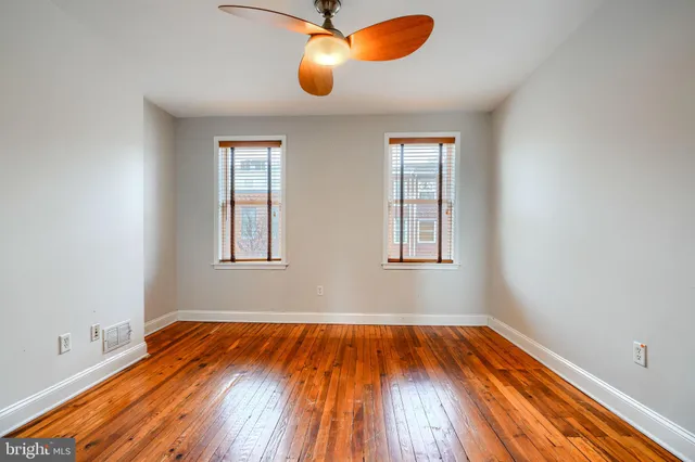 a view of a room with wooden floor and windows
