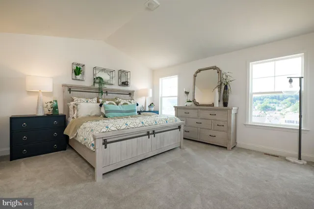 a bedroom with a bed and a dresser next to a window
