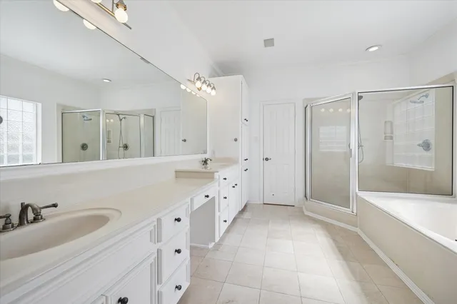 a spacious bathroom with a tub sink shower and mirror