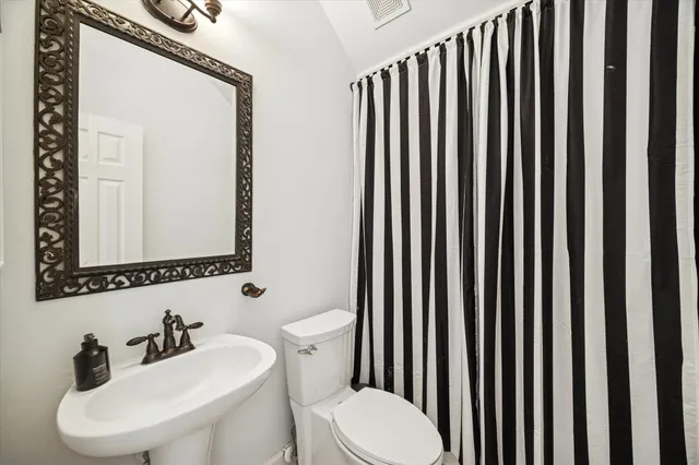 a bathroom with a toilet a sink and mirror