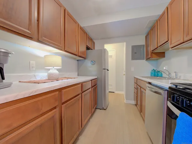 a kitchen with granite countertop a sink stove and cabinets