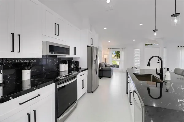 a kitchen with stainless steel appliances granite countertop a sink and a stove top oven