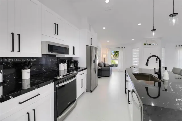 a kitchen with stainless steel appliances granite countertop a sink and a stove top oven