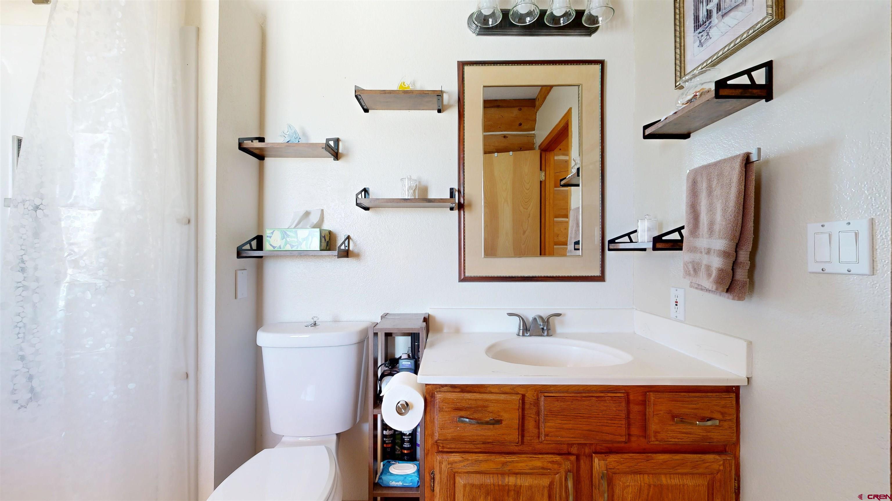2083 Pioneer Road Delta, CO 81416 - Photo 28 of 43 a bathroom with a sink vanity mirror and toilet