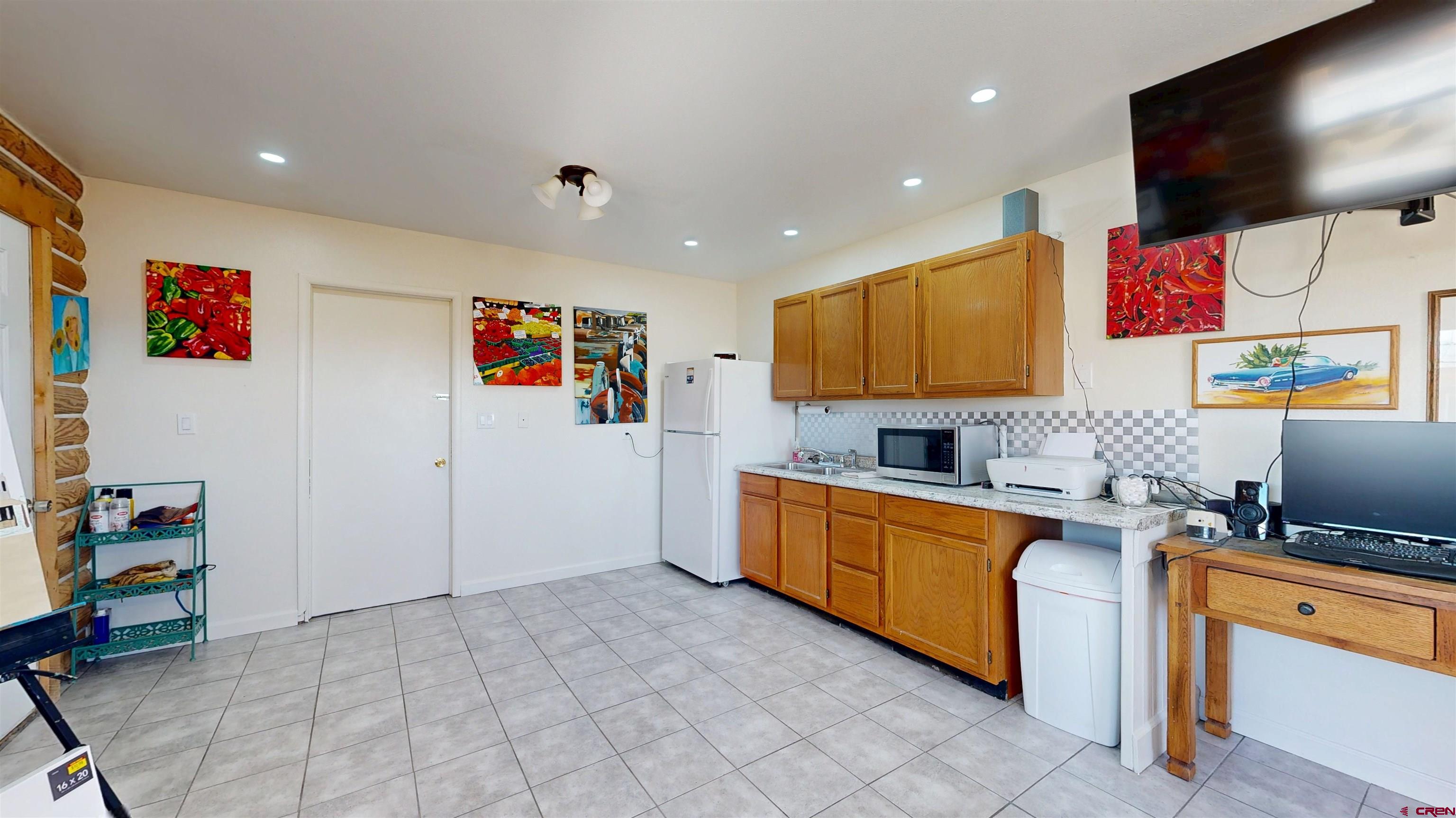 2083 Pioneer Road Delta, CO 81416 - Photo 33 of 43 a large white kitchen with a stove a sink and a flat screen tv